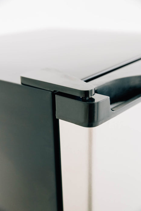 Stono Outdoor Living Close-up of the top corner of the TrueFlame 22" 4.1c Outdoor Approved Fridge (AMD-RFR-22S) with stainless steel, showing its hinge and part of the handle against a white background. Reversible door with lock feature is highlighted.