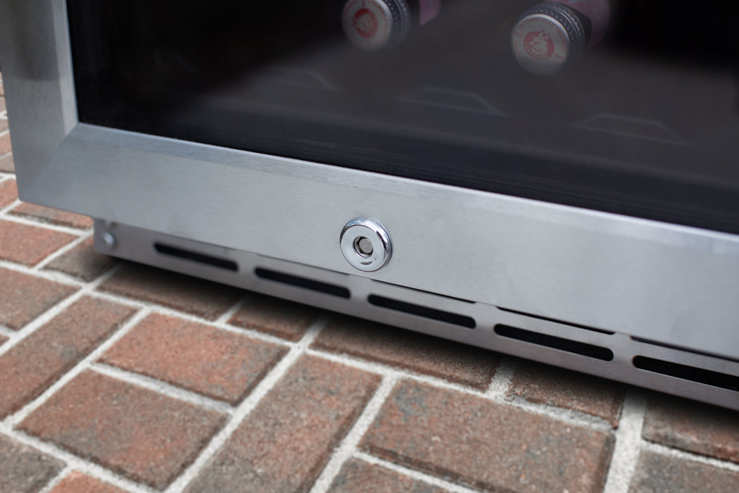 Stono Outdoor Living Close-up of the TrueFlame 15" 3.2 Cu. Ft. Outdoor Rated Refrigerator with Glass Door (AMD-RFR-15G) showing its lock and vent on a brick floor—perfect for outdoor kitchen setups.