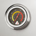 Stono Outdoor Living A close-up of a round metal thermometer with a black face (100–800°F, yellow and red zones) mounted on the stainless steel Delta Heat 32-Inch 3-Burner Built-In Propane Gas Grill with Sear Zone & Infrared Rotisserie (DHBQ32RS-DL).