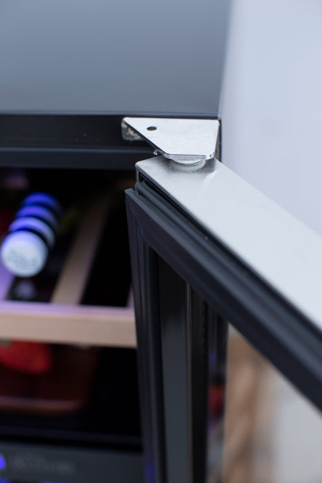 Stono Outdoor Living Close-up of an open TrueFlame 15" 3.2 Cu. Ft. Outdoor Rated Dual Zone Wine Cooler (AMD-RFR-15WD) door, highlighting the stainless steel hinge and interior shelves with bottles and containers visible.
