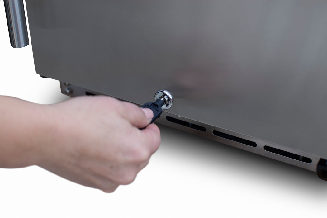 Stono Outdoor Living A hand inserts a key into the lock on the lower side of the TrueFlame 15" 3.2 Cu. Ft. Outdoor Rated Refrigerator (AMD-RFR-15S) by TrueFlame, ideal for outdoor kitchens or refrigeration setups.