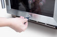 Stono Outdoor Living A hand inserts a key into the lock of the TrueFlame 15" 3.2 Cu. Ft. Outdoor Rated Single Zone Wine Cooler, with bottles visible inside through its glass door.