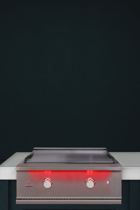 Stono Outdoor Living The TrueFlame 30" Built-In Natural Gas Grill Griddle (TFG30) by TrueFlame, featuring two illuminated red knobs, sits on a white countertop against a dark backdrop, bringing style and sophistication to any outdoor kitchen setup.