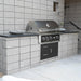 Stono Outdoor Living A Wildfire Ranch Pro 36-in 3 Burner Black 304 SS Natural Gas Grill (WFPRO36G-BSS-NG) by Wildfire Outdoor Living is installed in a grey concrete block counter with storage drawers on a modern patio with light stone flooring.