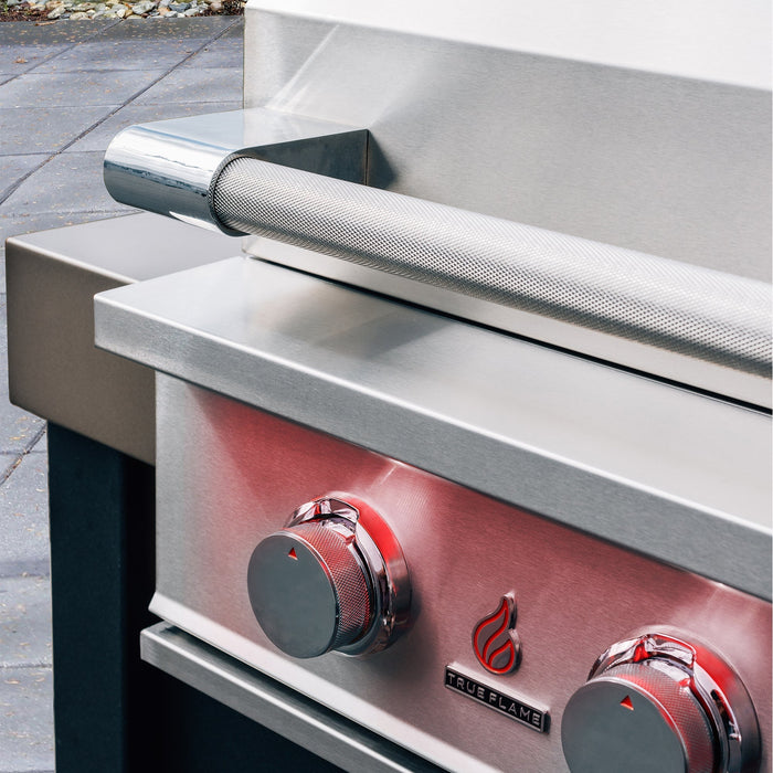 Stono Outdoor Living Close-up of the TrueFlame 40" 5-Burner Built-In Natural Gas Grill (TF40), featuring two red control knobs, a textured handle, and TrueFlame logo on the front. The stainless steel grill is set on a stone patio.
