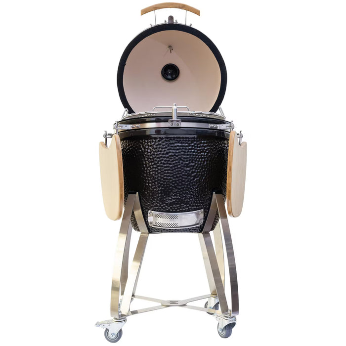 Stono Outdoor Living The Coyote Asado Smoker w/ Stand & Side Shelves (C1CHCS-FS) by Coyote is a black kamado-style charcoal grill with a domed lid, wooden side shelves, sturdy metal frame, and wheels for easy outdoor cooking—shown on a white background.