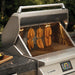 Stono Outdoor Living The Twin Eagles Wi-Fi Controlled 36-Inch Built-In Stainless Steel Pellet Grill and Smoker (TEPG36G) sits atop a stone countertop with its lid open, showcasing sausage links hanging inside—perfect for smoking or grilling at your next gathering.