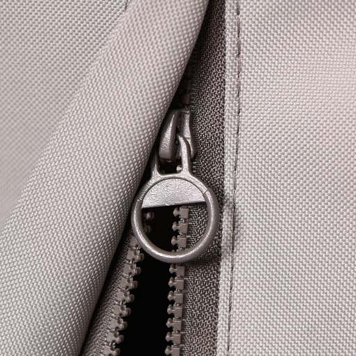 Stono Outdoor Living Close-up of a gray fabric zipper with round metal pull on the Coyote Cover for 36" Grill (CCVR36-BIG). This weather-resistant, textured cover by Coyote is ideal for protecting your outdoor grill.