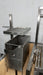 Stono Outdoor Living The Tagwood BBQ Height Adjustable Secondary Grate for BBQ09SS Grill (BBQ96SS) by Tagwood BBQ adds versatility to your grill, providing an adaptable cooking surface ideal for open flame or coal grilling against a light gray wall.