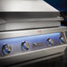 Stono Outdoor Living Close-up of the Twin Eagles Eagle One 42-Inch 3-Burner Built-In Propane Gas Grill (TE1BQ42RS-L), featuring blue-lit knobs, a large handle, and logo. Its infrared rotisserie burner stands out in an elegant evening outdoor setting.