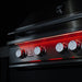 Stono Outdoor Living Close-up of the TrueFlame 40" 5-Burner Built-In Natural Gas Grill by TrueFlame, featuring five round control knobs illuminated by a red light, set against a dark background.