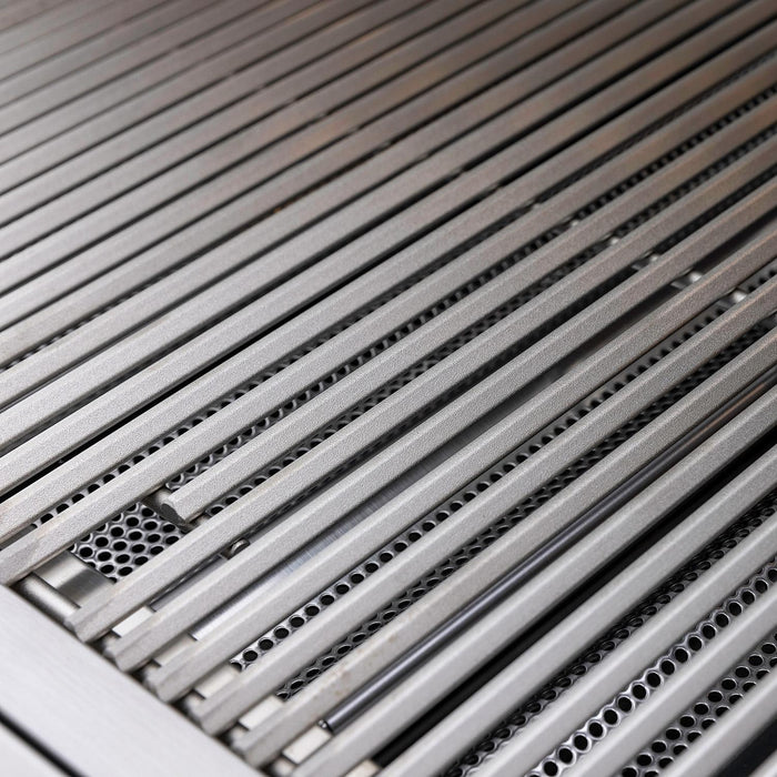Stono Outdoor Living Close-up of parallel stainless steel grill slats on the Blaze Premium LTE+ 32" 4-Burner Propane Grill, showing searing rods and perforated metal beneath. Brand: Blaze, Model: BLZ-4LTE3-LP.