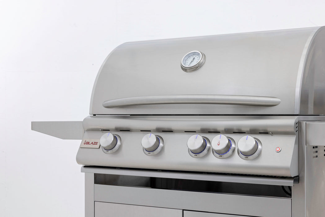 Stono Outdoor Living The Blaze Premium LTE+ Marine Grade 32" 4-Burner Propane Grill (BLZ-4LTE3MG-LP) features a stainless steel finish, rear infrared burner, grill lights, side shelf, four knobs, and a built-in temperature gauge—shown clean on a plain white background.