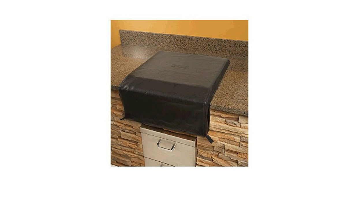 Stono Outdoor Living A Lynx Double with Prep Center Carbon Fiber Vinyl Cover (CCLSB2PC) from Lynx sits on a granite countertop with a stone facade, protecting the open drawer below. The setup is positioned against a yellow wall.