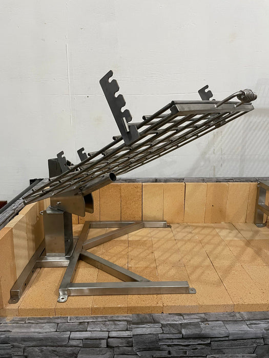 Stono Outdoor Living The Tagwood BBQ Basement Grill - BBQ94SS by Tagwood BBQ features a large SS 304 clamp grill grate with adjustable angled height, mounted over a brick and stone barbecue pit and supported by a sturdy notched metal frame.