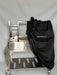 Stono Outdoor Living A Tagwood BBQ Grill Cover for BBQ23SS Grill - BBQ86SS, black and water-resistant, partially covers a stainless steel outdoor grill with shelving and accessories on wheels. The Tagwood BBQ logo is visible against a plain light background.