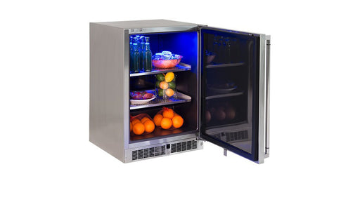 Stono Outdoor Living The Lynx 24" Outdoor Refrigerator (LN24REF) features stainless steel construction, blue interior lighting, and shelves stocked with bottled drinks, apples, oranges, and grapes—all visible with the door open.