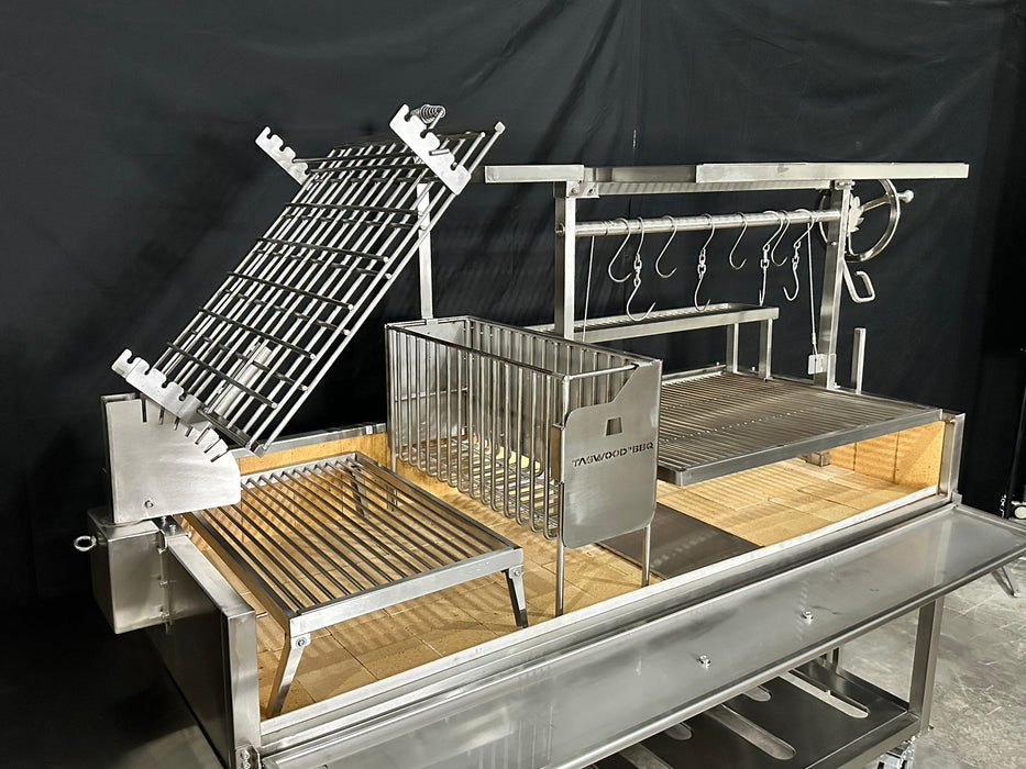 Stono Outdoor Living The Tagwood BBQ Argentine Santa Maria Wood Fire & Charcoal Grill (BBQ26SS) by Tagwood BBQ features 304 stainless steel, multiple racks, hooks, compartments, and adjustable grates for versatile cooking, inspired by classic Argentine grill designs.