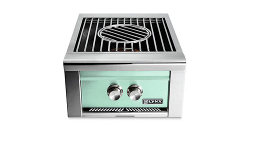 Stono Outdoor Living The Lynx Power Burner in Surf (LPB-SUNG) features a mint green front, high-BTU burner, two control knobs, and circular grate—ideal for outdoor kitchens. The Lynx brand is displayed on the lower right corner.