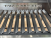 Stono Outdoor Living Close-up of the Tagwood BBQ V-Shape Grill Grate for BBQ23SS & BQ25SS grills, crafted from 304 stainless steel. "TAGWOOD BBQ" is etched on the bars—an ideal accessory for any outdoor kitchen or grilling setup.