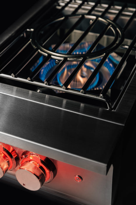 Stono Outdoor Living Close-up of the TrueFlame Propane Gas Power Burner - TFPBL by TrueFlame, featuring high BTU power, two red-lit control knobs, and a blue flame under a sturdy grate—ideal for any outdoor kitchen.