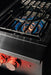 Stono Outdoor Living Close-up of the TrueFlame Natural Gas Power Burner - TFPB by TrueFlame, featuring high BTU side burners, two red-lit control knobs, and blue flames under a cast iron grate—ideal for outdoor kitchens.