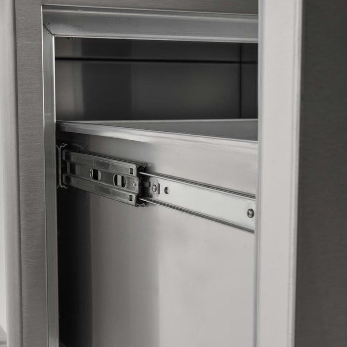 Stono Outdoor Living Close-up view of the Coyote 26" Pull Out Ice Chest (C3-CPOC) metal drawer slide mechanism inside an outdoor kitchen cabinet, showing clean rails and tracks for smooth opening and closing. Brand: Coyote.