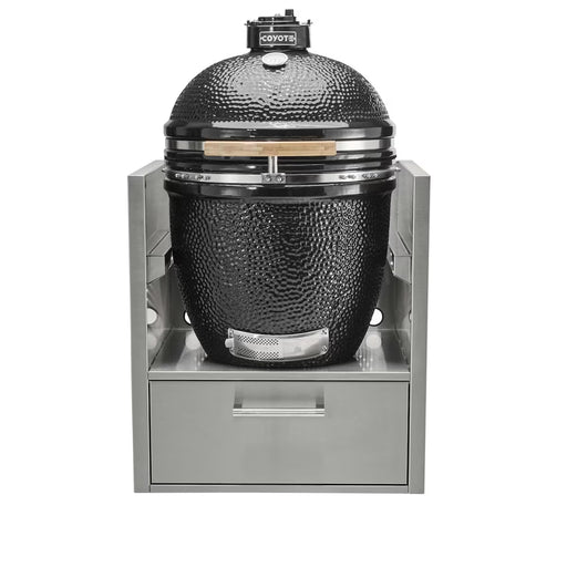 Stono Outdoor Living A Coyote Asado Smoker Insert Sleeve (C3SLV) houses a black ceramic kamado grill with Asado Smoker cooking grids, set in a stainless steel outdoor kitchen frame with a pull-out storage drawer below.