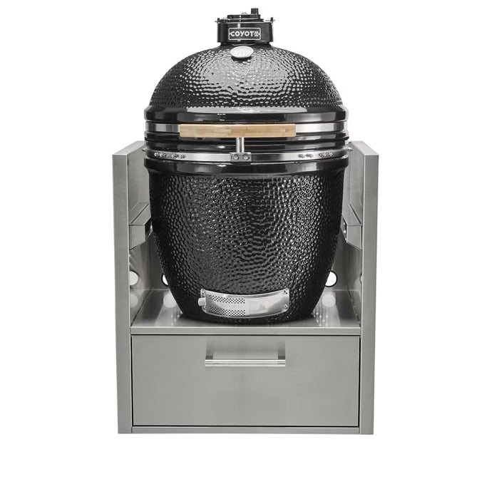 Stono Outdoor Living A Coyote Asado Smoker Insert Sleeve (C3SLV) houses a black ceramic kamado grill with Asado Smoker cooking grids, set in a stainless steel outdoor kitchen frame with a pull-out storage drawer below.