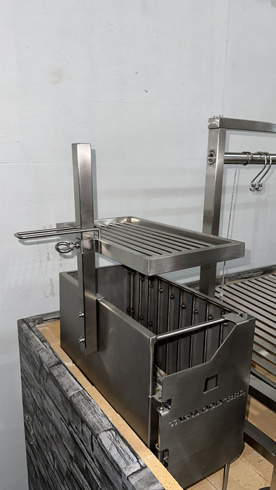 Stono Outdoor Living The Tagwood BBQ Height Adjustable Secondary Grate for the BBQ09SS Grill by Tagwood BBQ adds versatility and extra cooking space to your 304 stainless steel grill, designed for mounting on a stone or brick base against a light-colored wall.