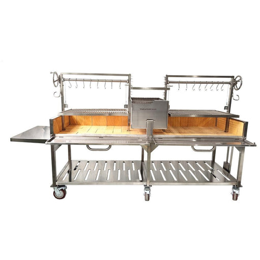 Stono Outdoor Living The Tagwood BBQ XL Double Argentine Santa Maria Wood Fire & Charcoal Grill (BBQ24SS) by Tagwood BBQ features 304 stainless steel, a wooden base, dual grilling racks, meat hooks, adjustable crank handles, central firebox, side shelf, and wheels.