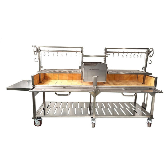 Stono Outdoor Living The Tagwood BBQ XL Double Argentine Santa Maria Wood Fire & Charcoal Grill (BBQ24SS) by Tagwood BBQ features 304 stainless steel, a wooden base, dual grilling racks, meat hooks, adjustable crank handles, central firebox, side shelf, and wheels.