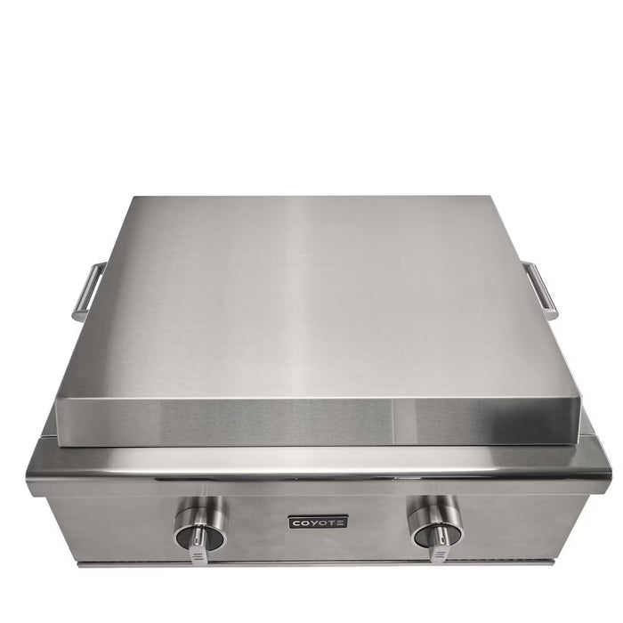 Stono Outdoor Living The Coyote 30" Flat Top Grill in Natural Gas (C3FTG30NG) features a closed lid, two control knobs, side handles, and a premium stainless steel cooking surface—perfect for your outdoor kitchen. The Coyote brand name is displayed above the knobs.