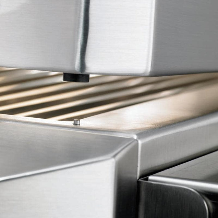 Stono Outdoor Living Close-up of a stainless steel panini press with upper and lower grooved plates and a small metal peg, shown alongside the Twin Eagles 42-Inch 3-Burner Built-In Propane Gas Grill (TEBQ42RS-CL) for a matching premium stainless steel look.