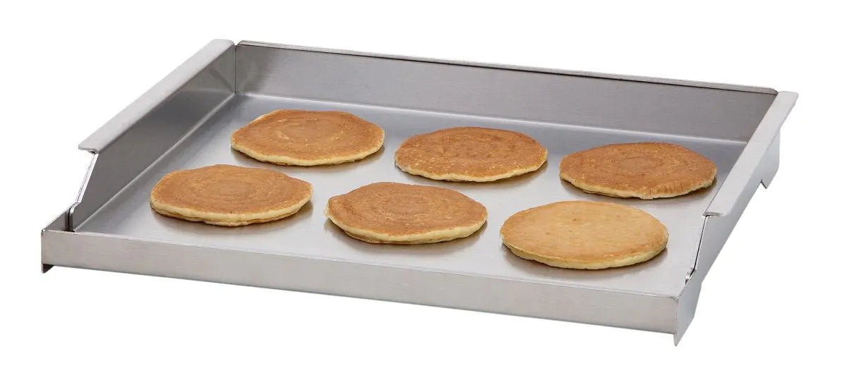 Stono Outdoor Living The Delta Heat Griddle Plate - DHGP18 by Delta Heat holds six evenly spaced golden-brown pancakes on its stainless steel surface, angled against a white background.