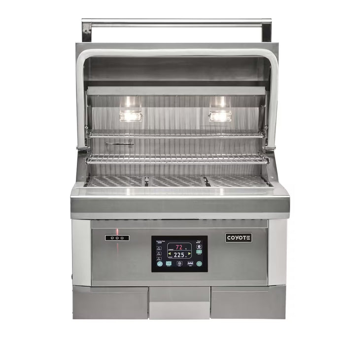 Stono Outdoor Living The Coyote 28" Pellet Grill - C2P28 is a stainless steel indoor grill with an open lid, two grilling racks, interior lights, and an advanced digital control panel showing temperature settings. The Coyote brand logo appears on the lower right.