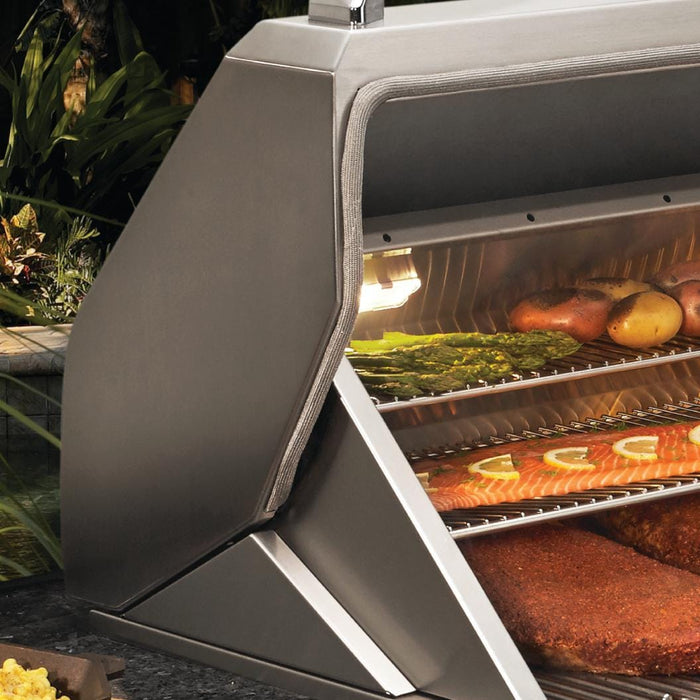 Stono Outdoor Living Close-up of the Twin Eagles Wi-Fi Controlled 36-Inch Stainless Steel Pellet Grill and Smoker with Rotisserie (TEPG36R), lid open to reveal racks of vegetables, fish, and meat—ideal for outdoor cooking amid lush greenery.