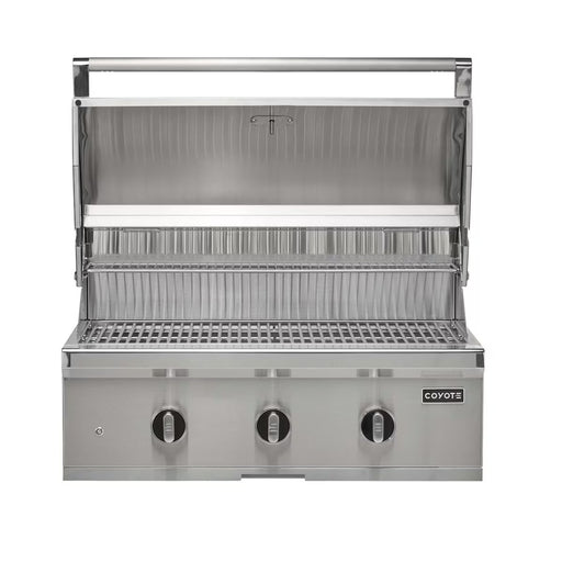 Stono Outdoor Living The Coyote 34" C-Series Grill (C3C34NG) is a built-in natural gas grill with three control knobs, a closed lower compartment, and an open lid showing the grate. The Coyote brand logo appears on the front panel.