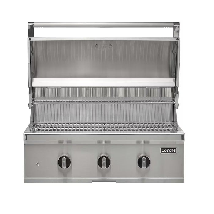 Stono Outdoor Living The Coyote 34" C-Series Grill (C3C34NG) is a built-in natural gas grill with three control knobs, a closed lower compartment, and an open lid showing the grate. The Coyote brand logo appears on the front panel.