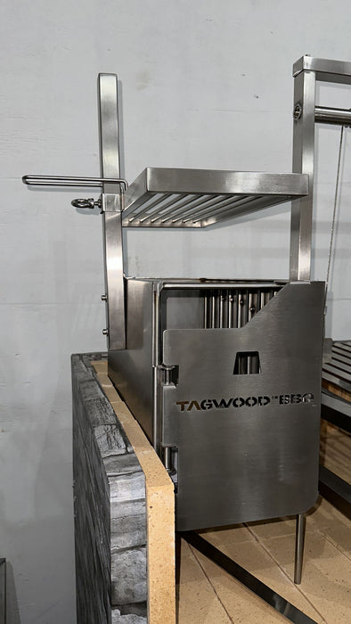 Stono Outdoor Living The Tagwood BBQ Height Adjustable Secondary Grate for the BBQ09SS Grill, model BBQ96SS, by Tagwood BBQ features an adjustable rack and metal rods, designed for a stone counter setup against a light gray wall.