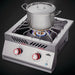 Stono Outdoor Living A stainless steel pot with a lid sits on the Napoleon Built-In 700 Series Propane Gas Power Burner (BIB18PBPSS), which features two red knobs and a blue flame, as steam rises from the pot.