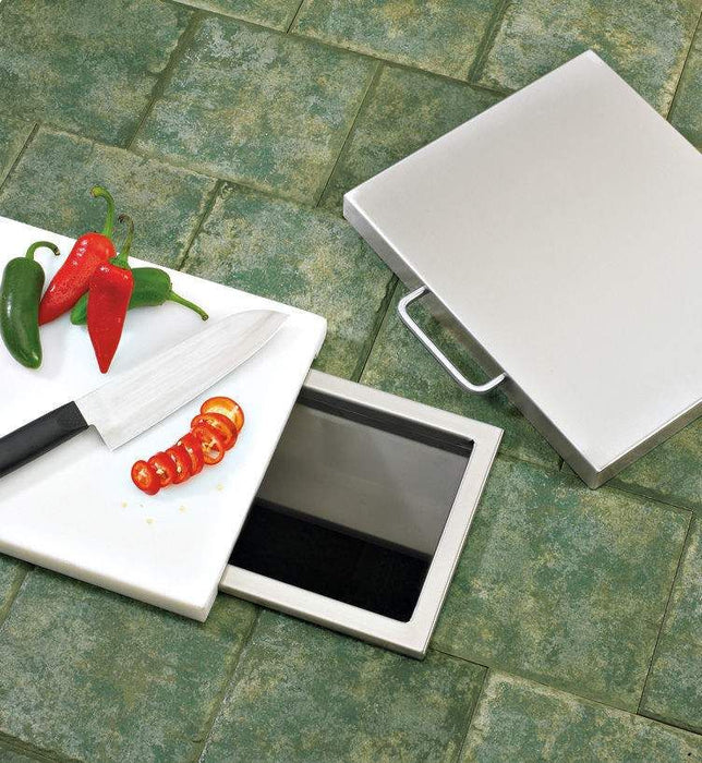 Stono Outdoor Living A kitchen floor features the Delta Heat Trash Chute - DHTC by Delta Heat. Its open lid reveals storage beneath, while a removable cutting board above holds sliced tomatoes, a knife, and chili peppers.